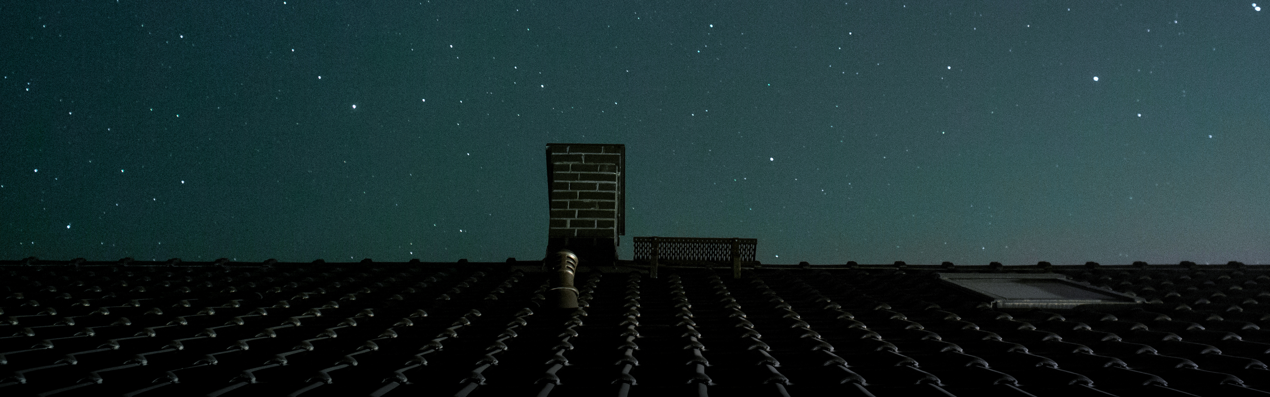 Chimney and roof line view at night with stars in the background