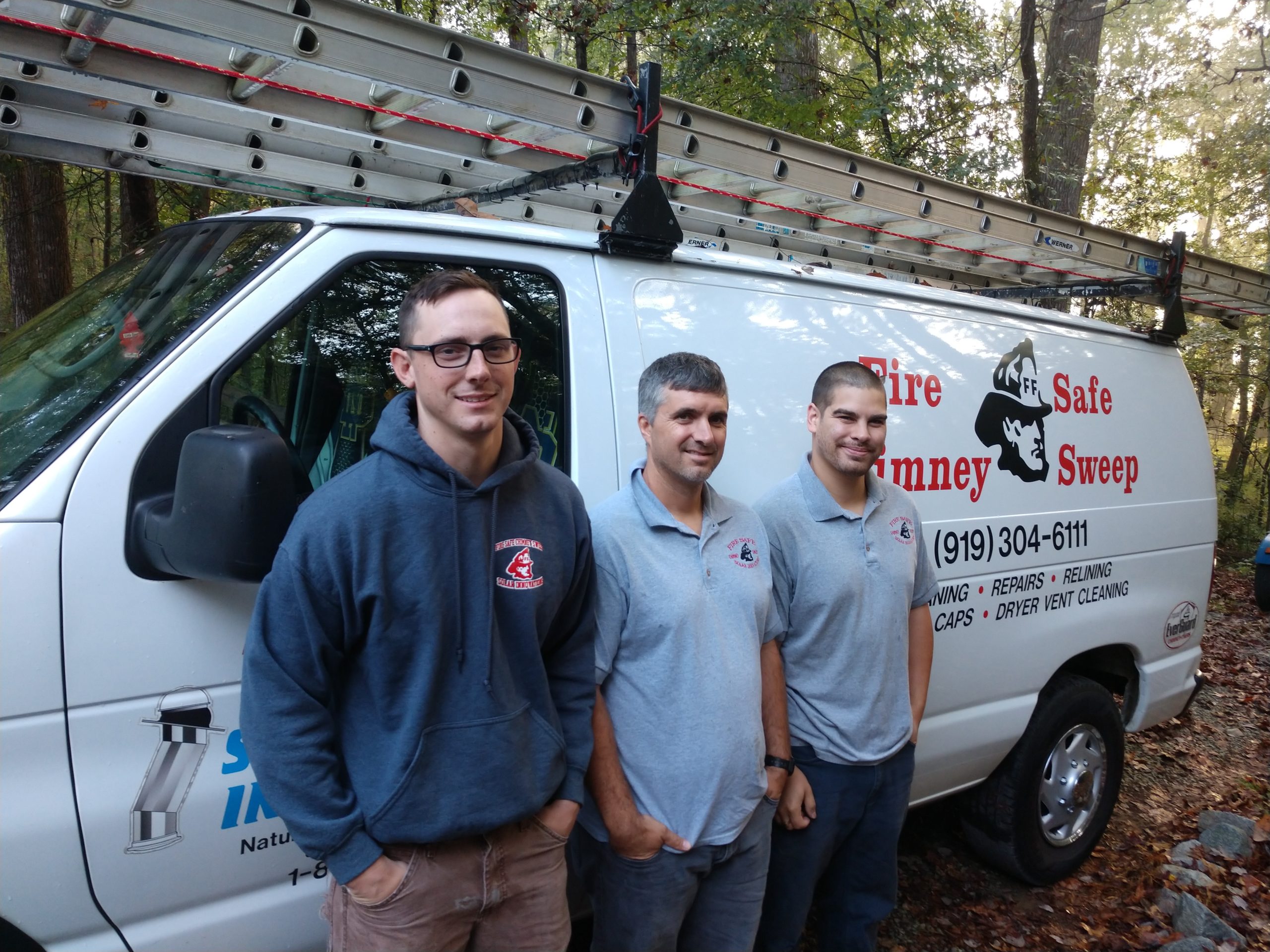 Professional techs Caleb Sharpe, Leonard Rhew, & Kevin Ellis standing in front of Fire Safe  truck with ladders on top